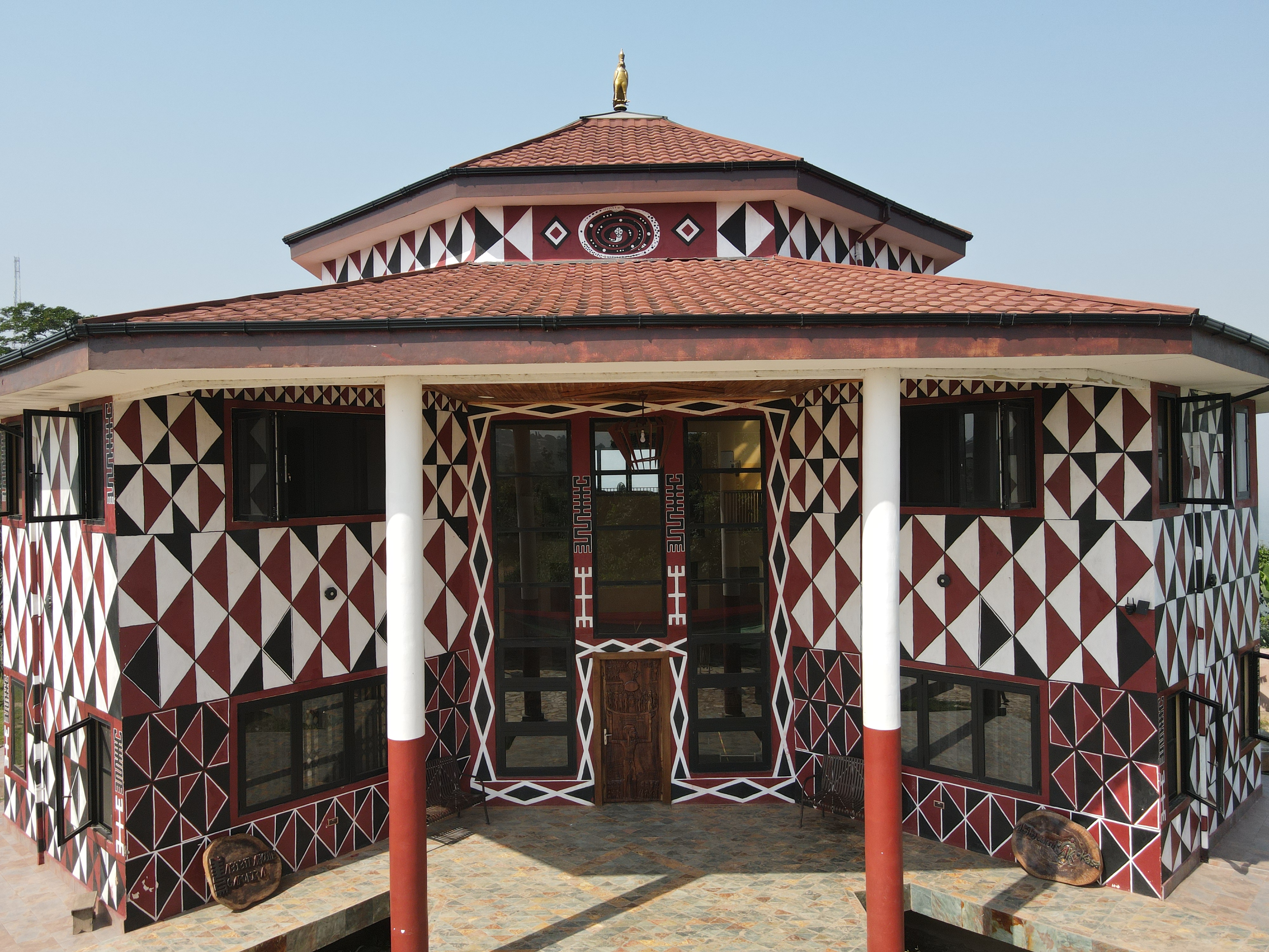 Actual proof-of-concept building with geometric exterior decoration, white columns and a tiled hipped roof